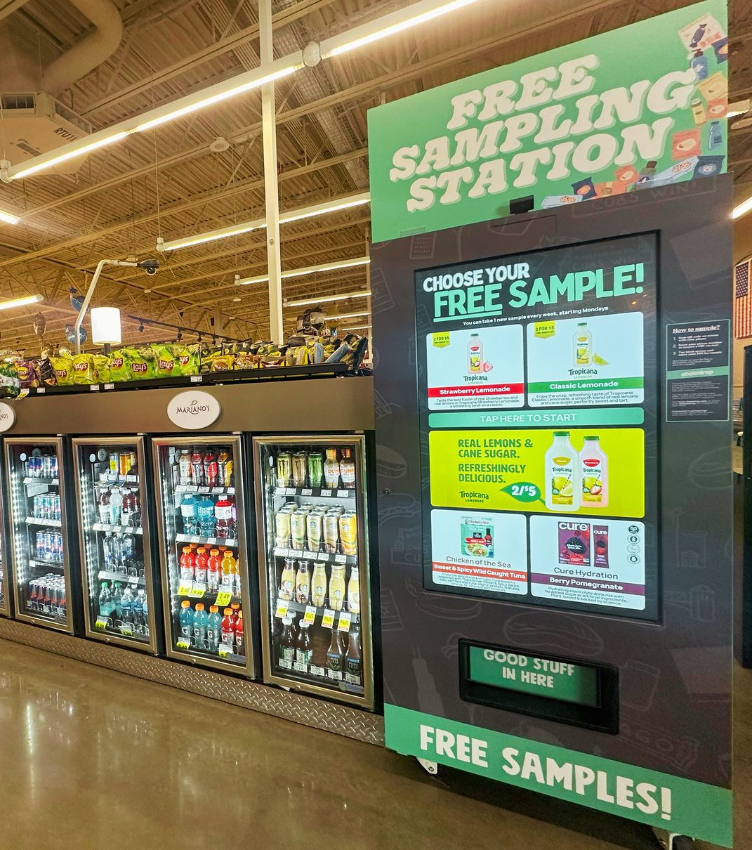 A Showdrop kiosk offering free samples beside the cold beverage doors