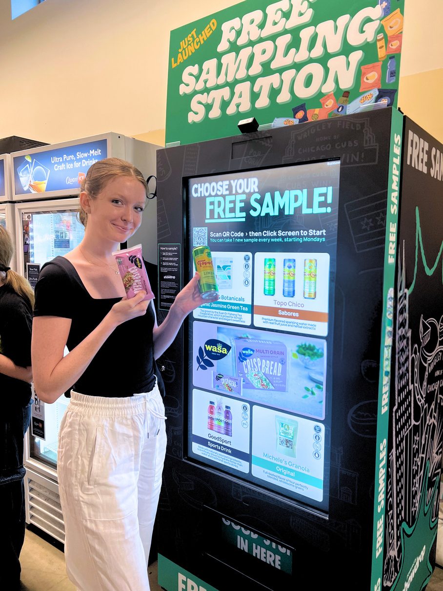 A shopper holding her sample at the kiosk